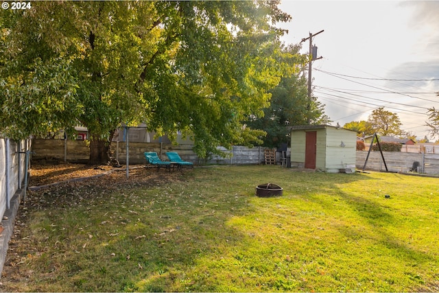 view of yard with a fire pit and a storage unit