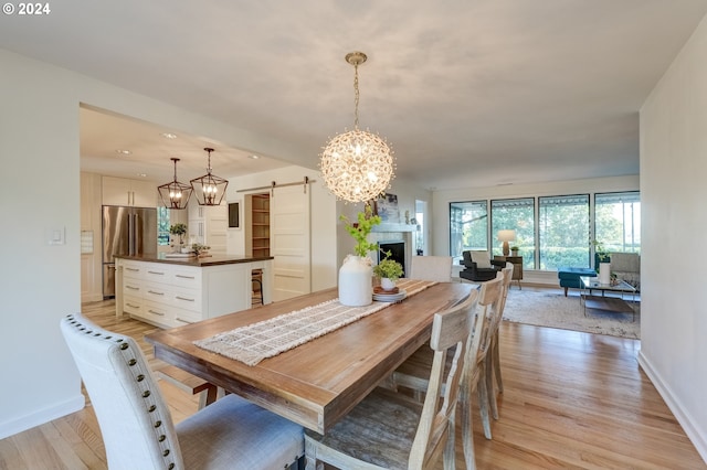 dining space with a barn door and light hardwood / wood-style floors