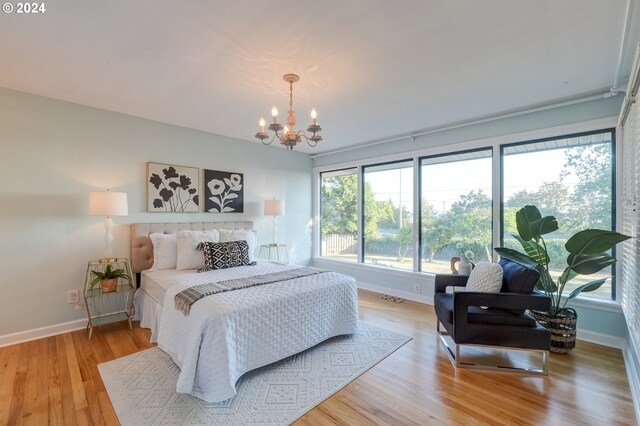 bedroom featuring light wood-type flooring and a chandelier