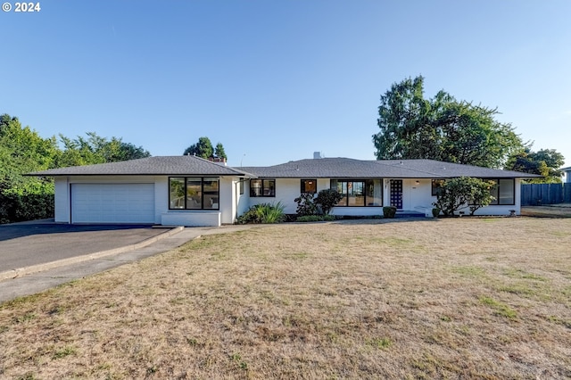 ranch-style house featuring a garage and a front yard