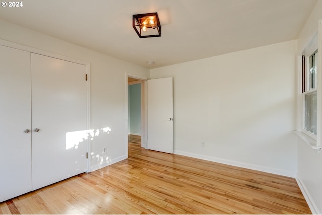 unfurnished bedroom with light hardwood / wood-style flooring and a closet