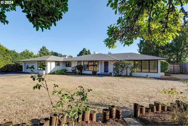 ranch-style home featuring a garage and a front yard