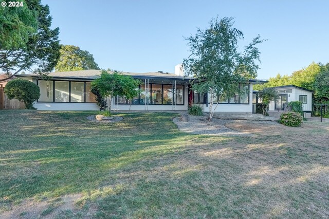 view of front of property with a sunroom and a front yard