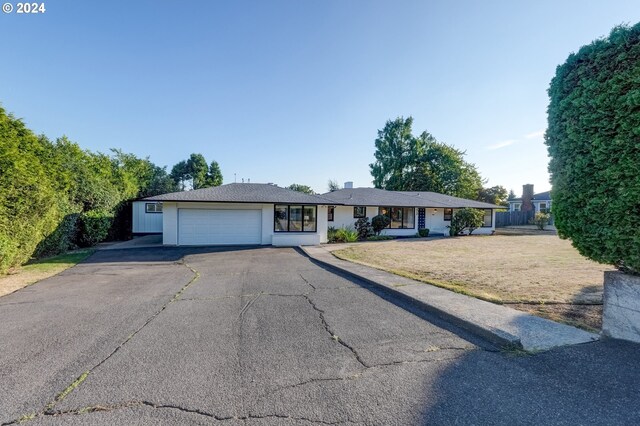 ranch-style home featuring a garage and a front yard