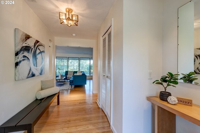 hallway featuring an inviting chandelier and light wood-type flooring