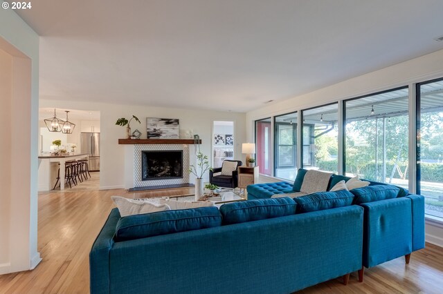 living room featuring a wealth of natural light, light hardwood / wood-style flooring, and a notable chandelier