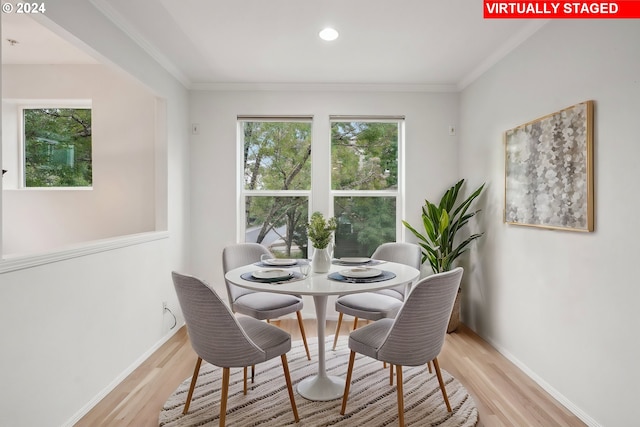 dining room with crown molding and light wood-type flooring