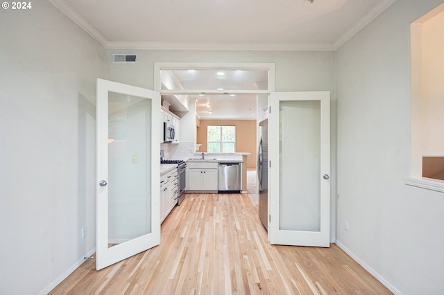 kitchen featuring french doors, white cabinets, stainless steel appliances, and light wood-type flooring