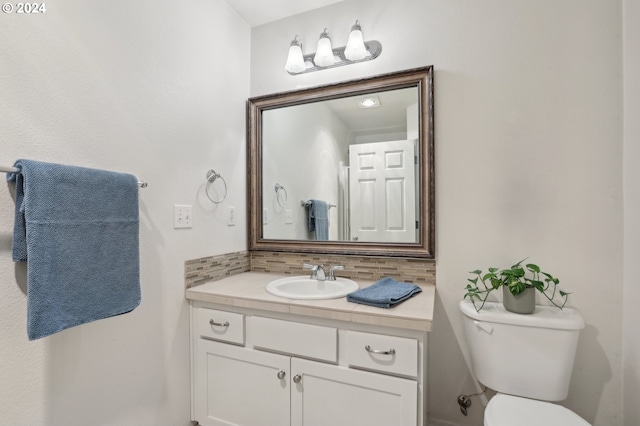 bathroom featuring tasteful backsplash, vanity, and toilet