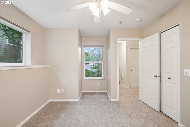 unfurnished bedroom featuring ceiling fan and light colored carpet