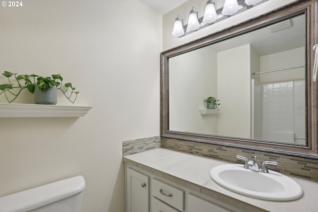 bathroom featuring decorative backsplash, toilet, walk in shower, and vanity