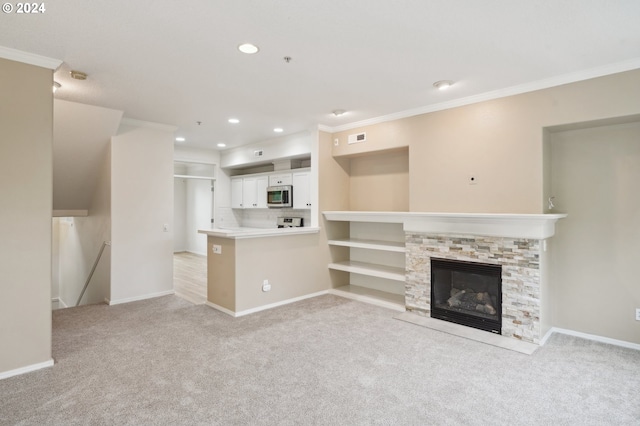 unfurnished living room featuring light colored carpet, a stone fireplace, and crown molding