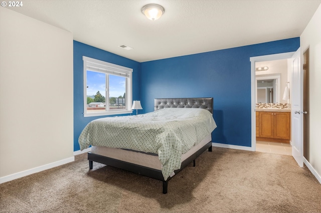 carpeted bedroom with ensuite bath