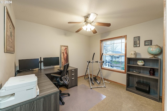 carpeted office space featuring ceiling fan and a textured ceiling