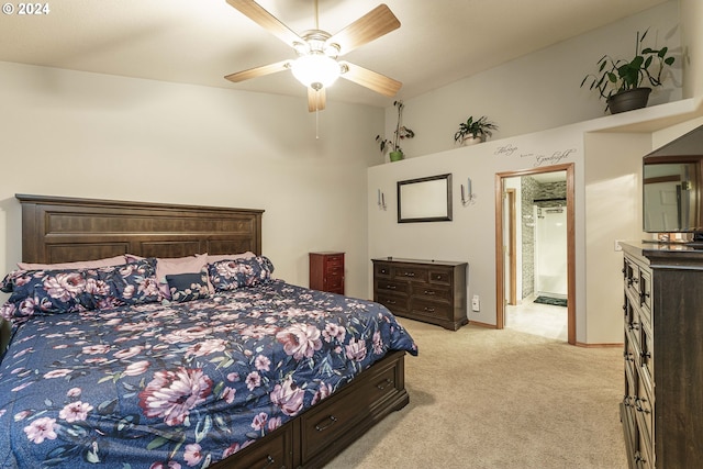 bedroom featuring light carpet, ensuite bathroom, and ceiling fan