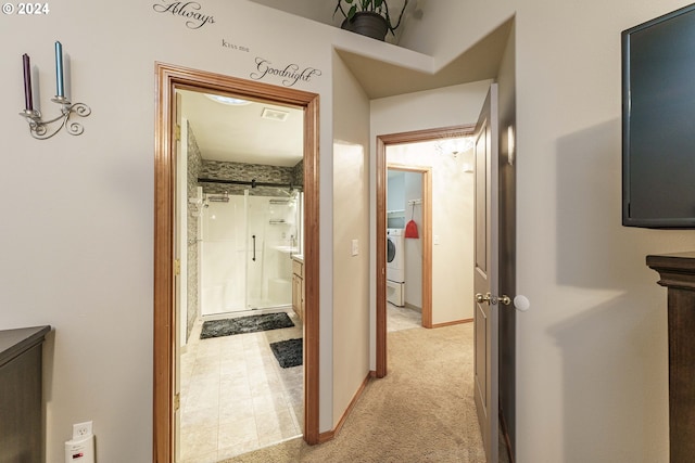 hall featuring washer / clothes dryer and light colored carpet