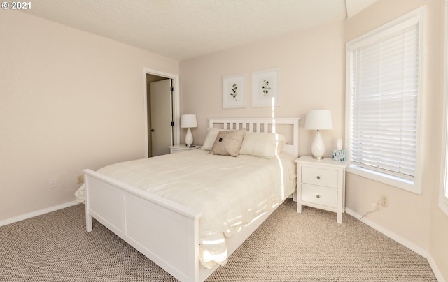 bedroom featuring light carpet and a textured ceiling