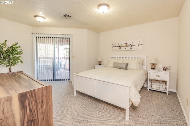 carpeted bedroom with access to exterior and a textured ceiling