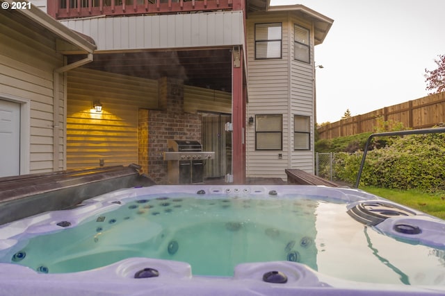 view of pool featuring area for grilling and a hot tub