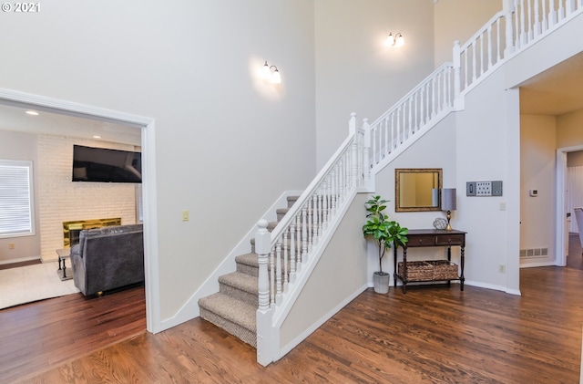 stairs featuring dark hardwood / wood-style floors and a towering ceiling