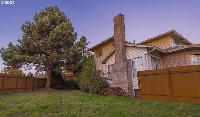 property exterior at dusk with a yard