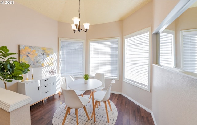 dining area with dark hardwood / wood-style floors and a notable chandelier