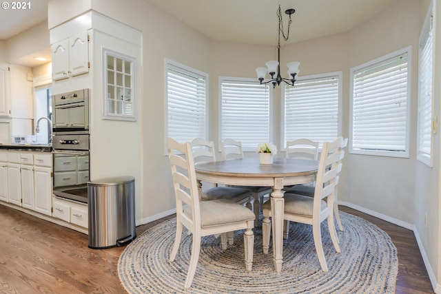 dining space featuring a healthy amount of sunlight, a notable chandelier, and wood-type flooring