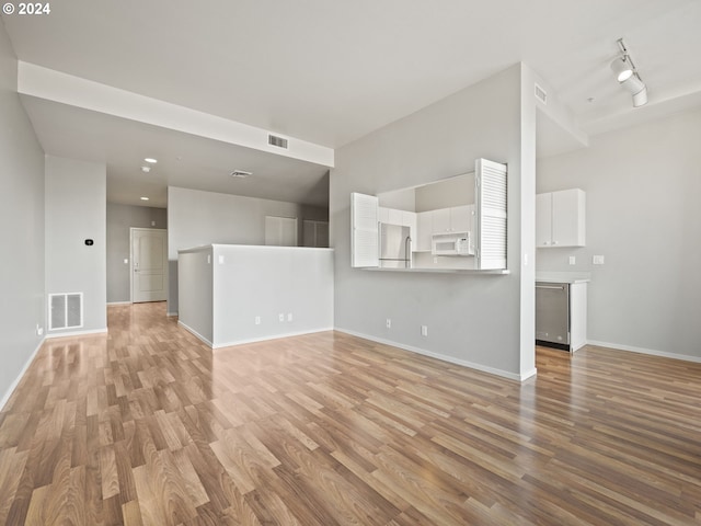 unfurnished living room featuring light wood-type flooring and track lighting