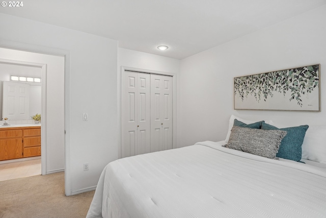 bedroom with ensuite bathroom, sink, a closet, and light colored carpet