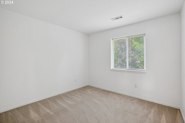 unfurnished room featuring light carpet