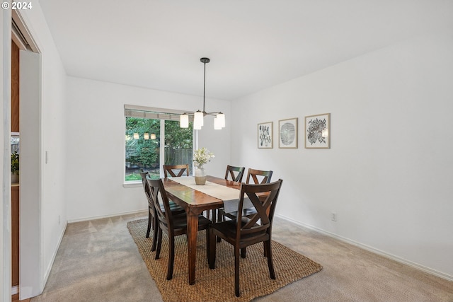 carpeted dining room featuring a notable chandelier