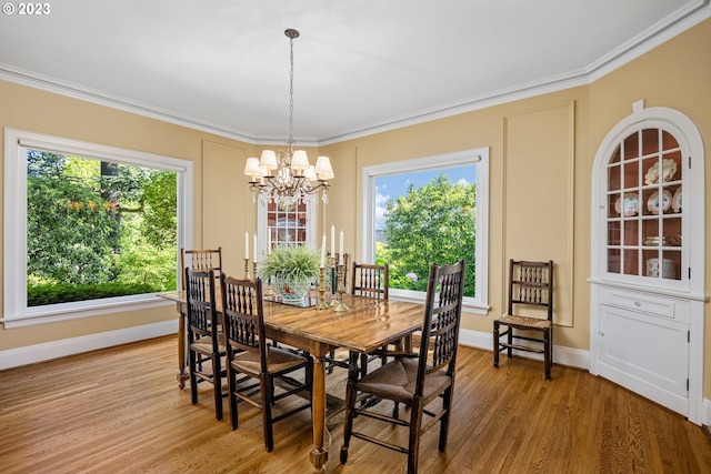 dining room featuring ornamental molding, a notable chandelier, a wealth of natural light, and light hardwood / wood-style floors