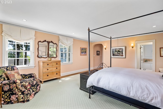 bedroom with ornamental molding and ensuite bathroom