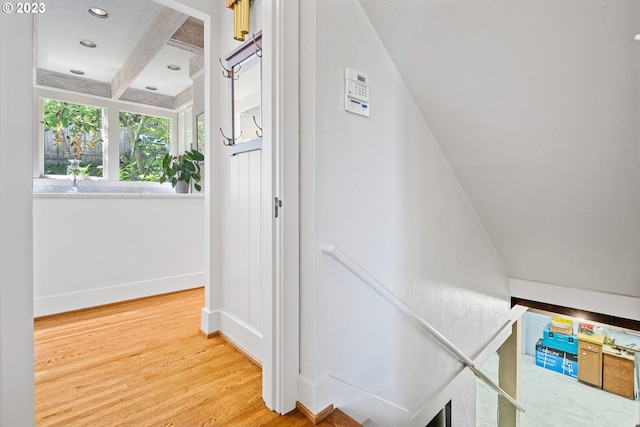 stairway with beamed ceiling and wood-type flooring