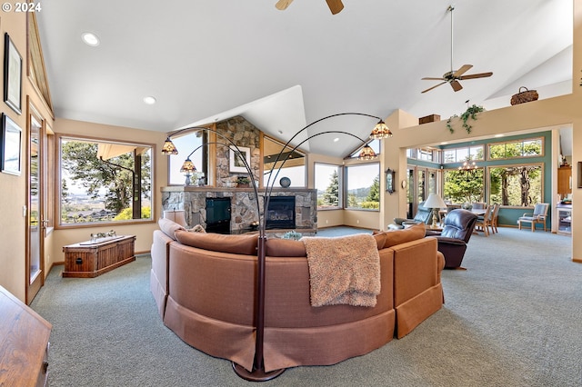 living room with carpet floors, a stone fireplace, ceiling fan, and lofted ceiling