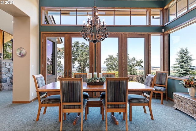 dining room with carpet, a wealth of natural light, and an inviting chandelier