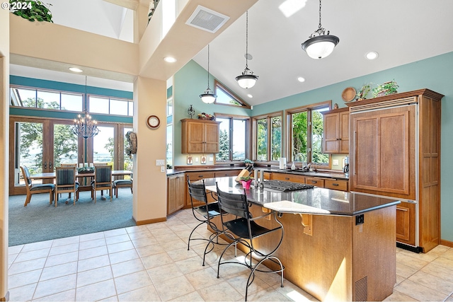 kitchen with a center island, french doors, high vaulted ceiling, dark stone countertops, and light carpet