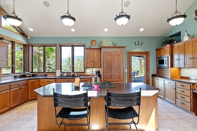 kitchen with a breakfast bar, stainless steel appliances, and vaulted ceiling