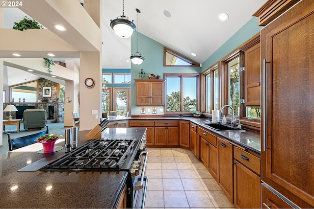 kitchen with pendant lighting, stainless steel gas stove, a healthy amount of sunlight, and sink