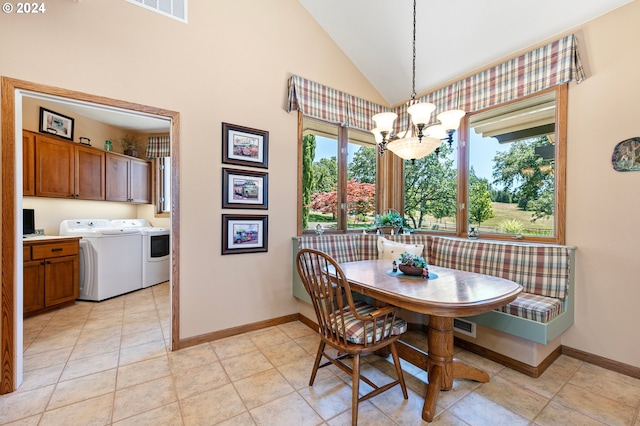 tiled dining area with breakfast area, washer and dryer, lofted ceiling, and a chandelier