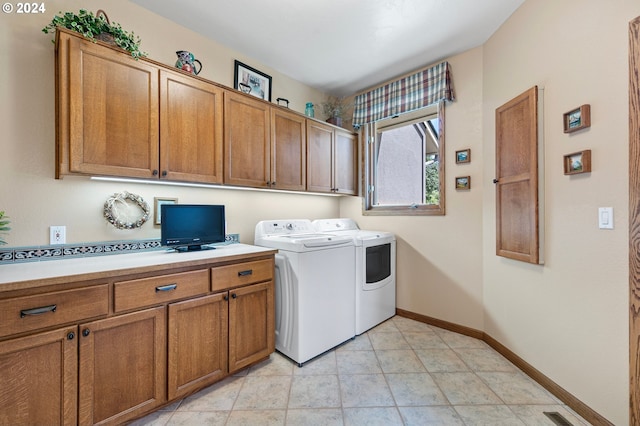 clothes washing area with washing machine and clothes dryer and cabinets