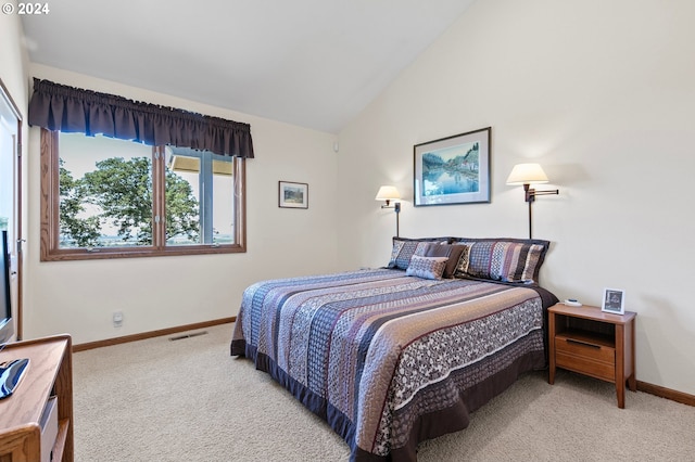 carpeted bedroom with lofted ceiling