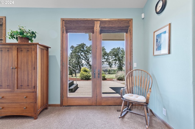 doorway with a healthy amount of sunlight, light colored carpet, and french doors