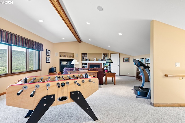 rec room with a tile fireplace, built in shelves, lofted ceiling with beams, and light colored carpet