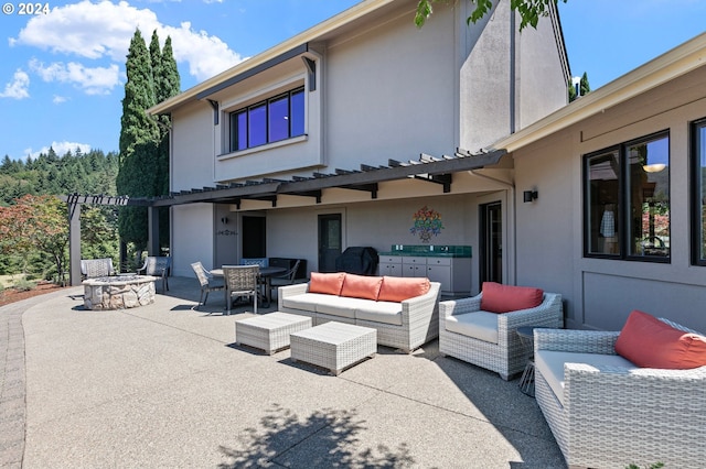 rear view of property with a patio area and an outdoor living space with a fire pit