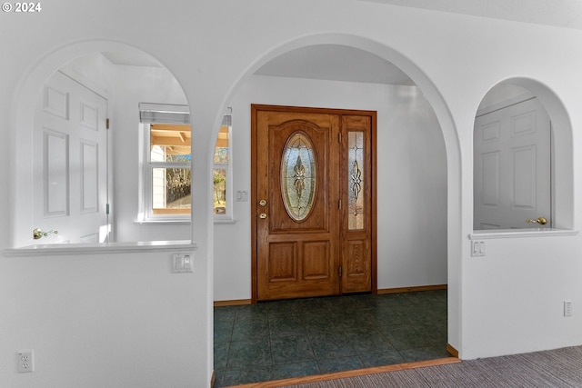 foyer entrance featuring dark tile patterned flooring