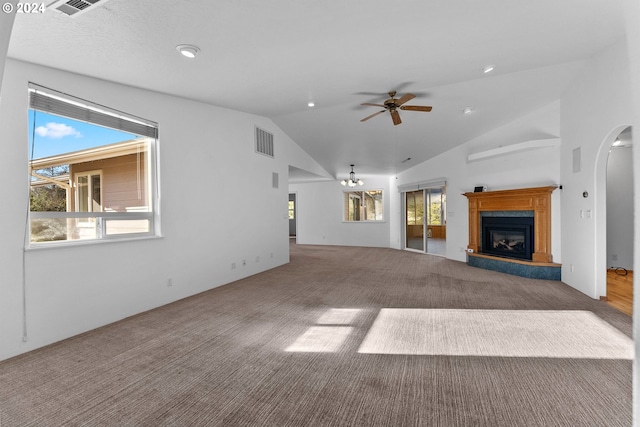 unfurnished living room featuring carpet, a healthy amount of sunlight, and vaulted ceiling