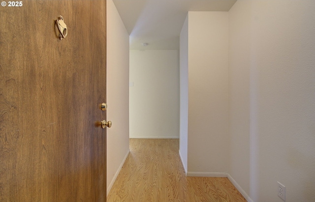 corridor with wood finished floors and baseboards