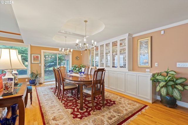 dining space featuring a notable chandelier, light wood-type flooring, and ornamental molding