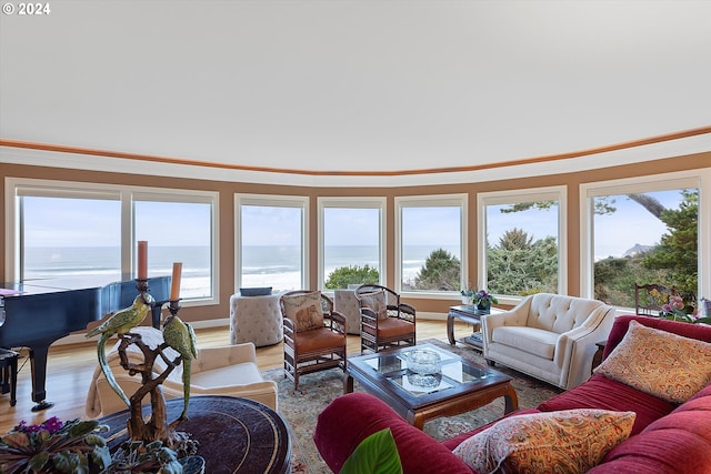 living room with crown molding, a water view, and hardwood / wood-style flooring